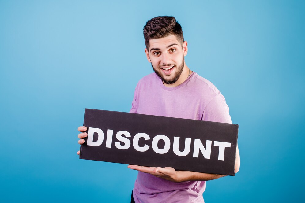 A person holding a large black sign with the word DISCOUNT in bold white letters, against a bright blue background.