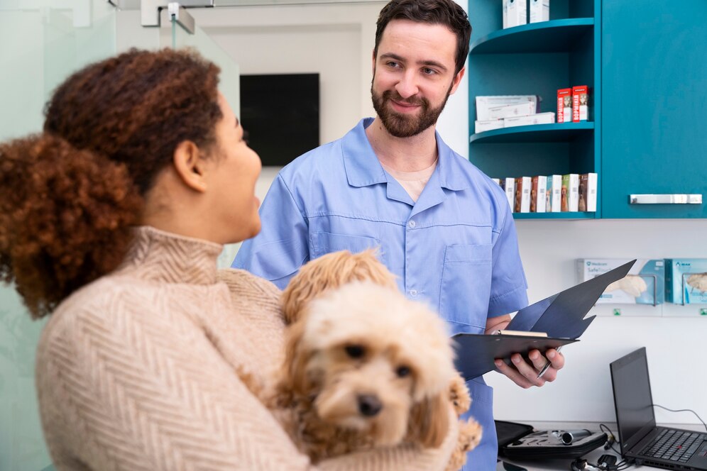 Veterinarian talking to a woman holding a small dog at a pet clinic, discussing different types of pet insurance.